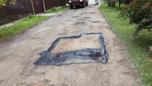 Ikšķiles iedzīvotājus pārsteidz redzētais – bedres uz grants ceļa “lāpa” ar asfalta klucīšiem